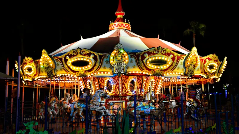 Carrusel de feria iluminado de noche con caballitos y luces doradas