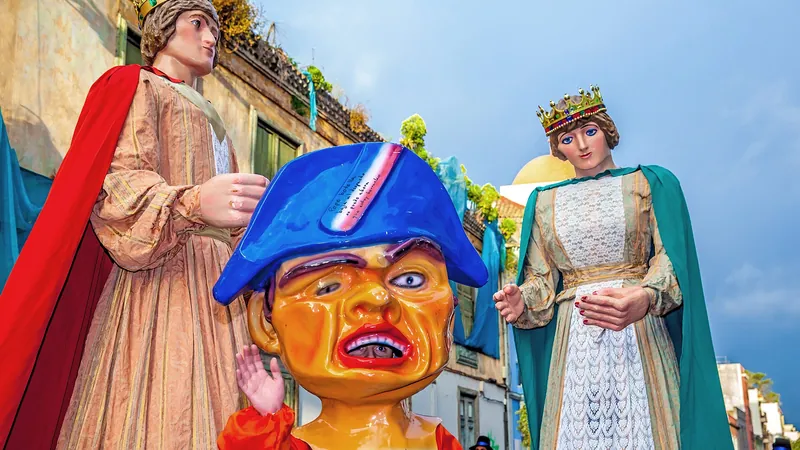 Gigantes y cabezudos de colores desfilando por una calle en fiestas