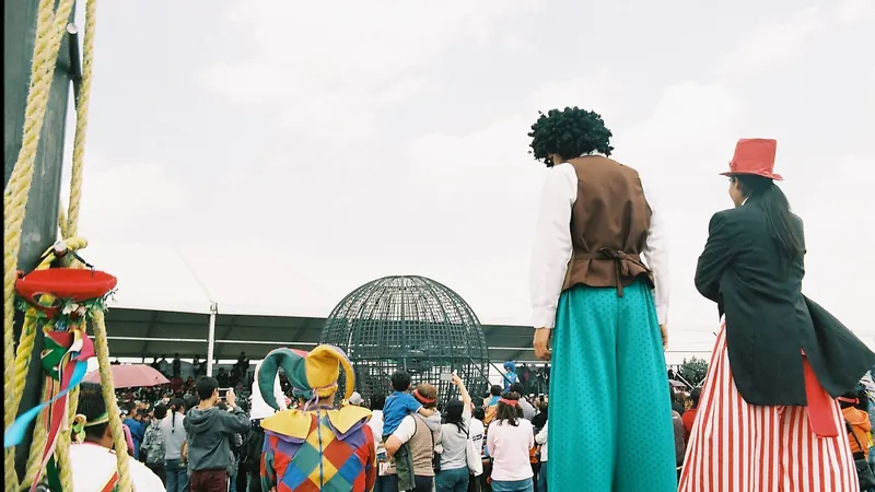 Artistas de circo con zancos y trajes de colores junto a la carpa