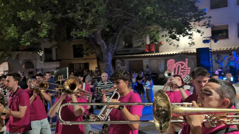 Charanga tocando trombones y trompetas por la calle en una noche de fiestas